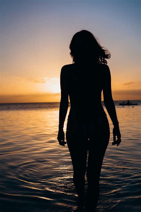 Silhouette Of Woman Standing N Body Of Water Photo Free Silhouette