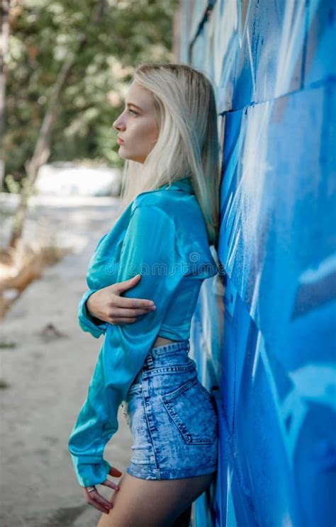 Young Girl Blonde Poses On A Background Of A Wall With Graffiti Stock