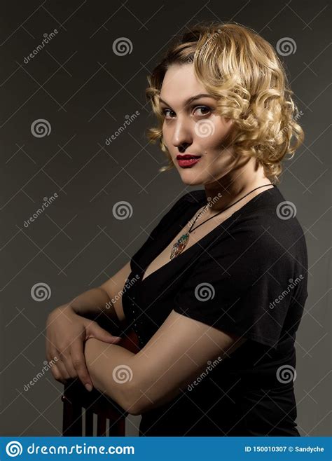 Retro Portrait Of Beautiful Woman In Black Dress Sitting