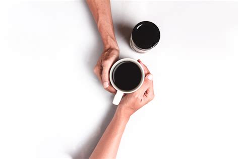 persons hand holding white mug filled  coffee  stock photo