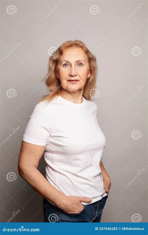 Vieille Femme Adulte Mature Et Heureuse Portant Un Tshirt Blanc Debout