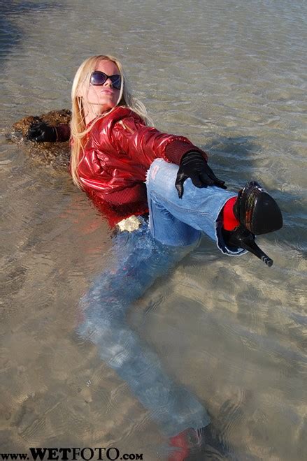 wet girl in red jacket tight jeans and high heels by the sea wetlook one