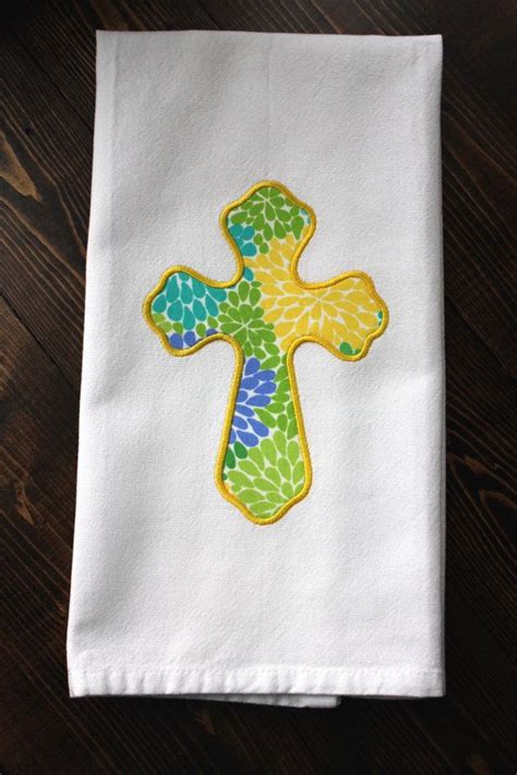 white towel   colorful cross   sitting  top   wooden table