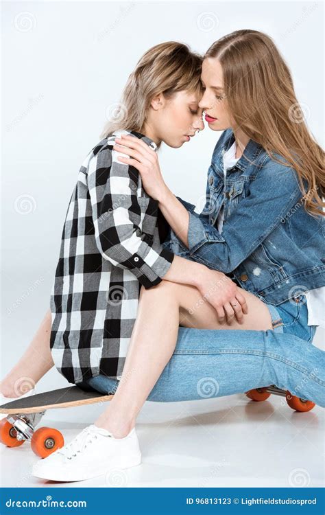 Beautiful Lesbian Couple Sitting And Hugging On Skateboard Stock Image