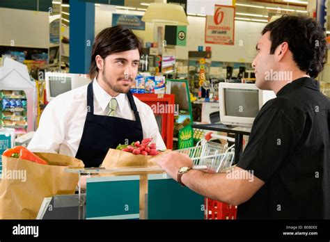 sales clerk selling products   costumer   supermarket stock photo