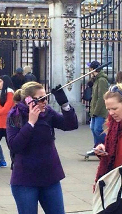 woman outside buckingham palace answers smartphone while it s hooked up