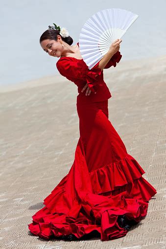 traditional woman spanish flamenco dancer in red dress with fan stock
