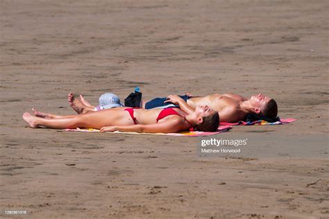 A Man And Woman Sunbathing At Whitmore Bay Beach Barry Island On