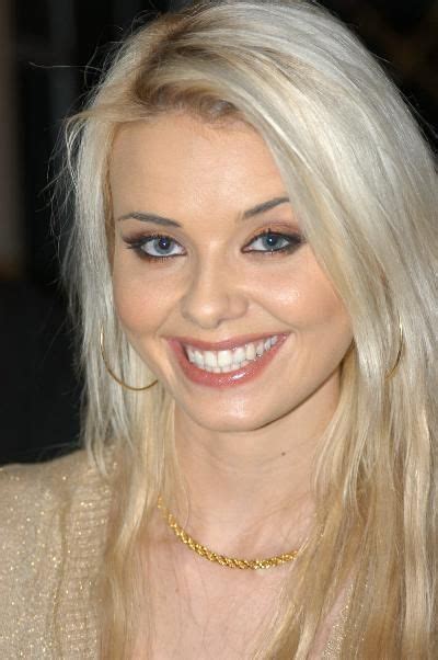 A Woman With Blonde Hair And Blue Eyes Smiling