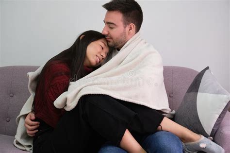 Young Romantic Couple Covered With A Blanket Hugging Sitting On The