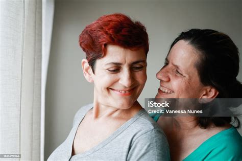 Senior Gay Lesbian Couple Hugging Each Other Inside Home Lgbtq Aged