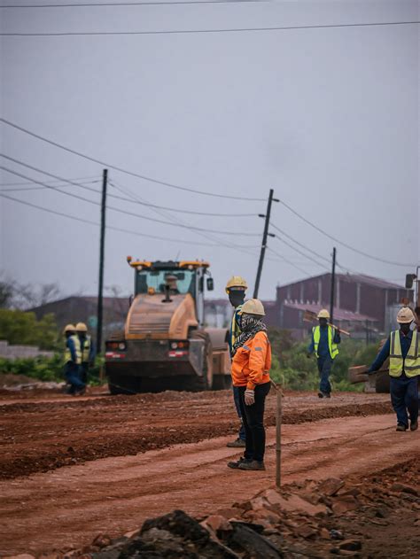 Pekerja Konstruksi Di Lokasi Pekerjaan Jalan Dengan Mesin Berat · Foto ...