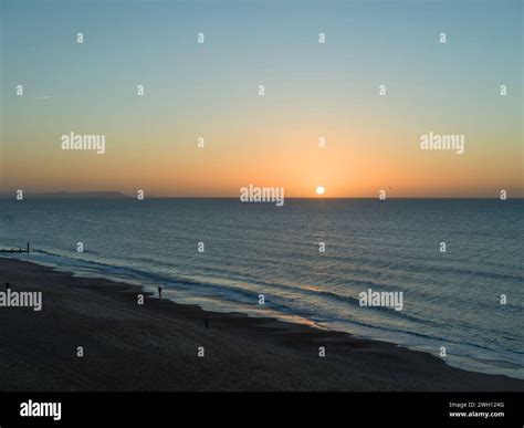 The January sun has risen above the horizon over the calm sea. People ...