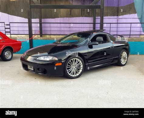 Old sport black Mitsubishi Eclipse GSX 1999 in a warehouse yard. Front ...