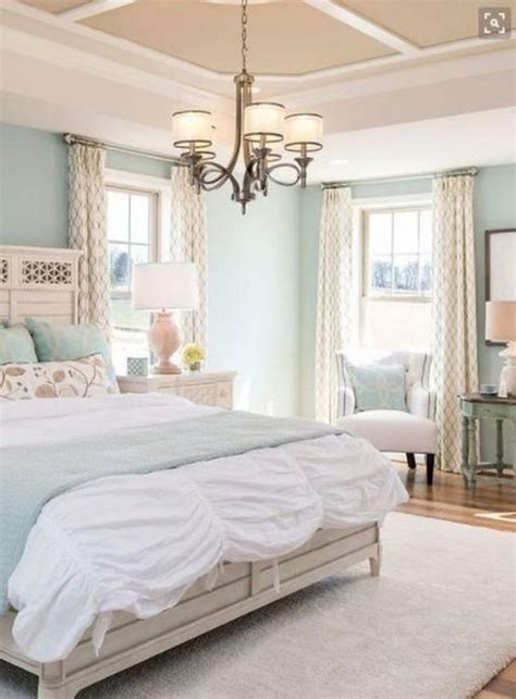 A gorgeous bedroom with light blue walls, white crown molding and dark ...