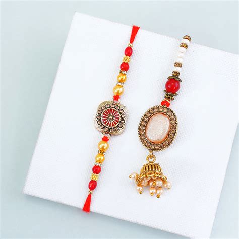 Send Alluring Couples Rakhi with Buddha Statue Gift Pack Online