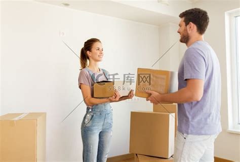 抵押贷款、人和房地产概念-幸福的夫妻带着箱子搬到新家。高清摄影大图-千库网