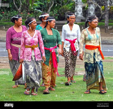 Balinese women dressed in traditional baju and batik sarongs at a ...