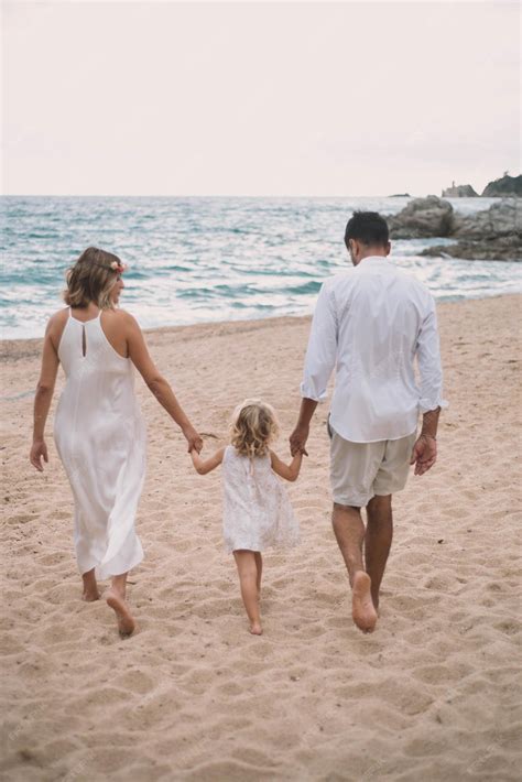 Beautiful family walking along a mediterranean beach | Premium Photo