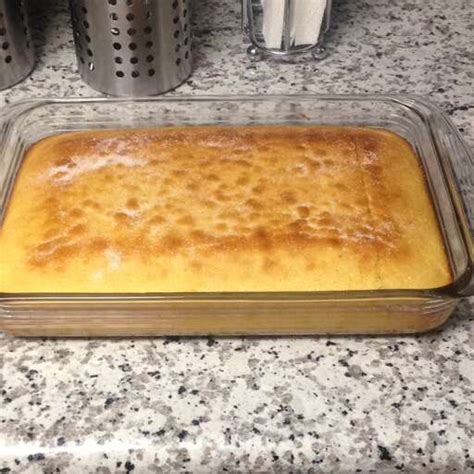 side view of Vaselopita - Greek New Years Cake dusted with powdered sugar with a slice cut out of it