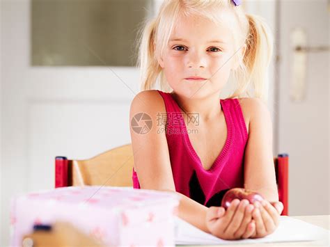 桌子上拿着苹果的女孩高清图片下载-正版图片501440185-摄图网