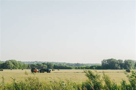 Tractor plows the floor. haystacks after working with a tractor farming ...