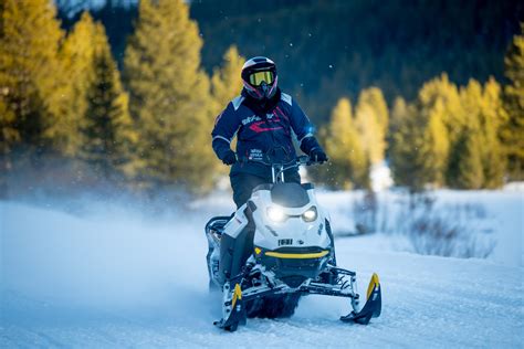 Rider riding up a snowy mountain on the 2027 Ski-Doo Summit