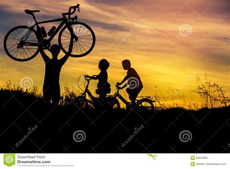现出轮廓在他的头上的人立场举的自行车有小男孩和小女孩在日落的骑马自行车的 库存照片 - 图片 包括有 现出轮廓在他的头上的人立场举的自行车有小 ...