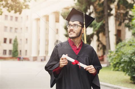 年轻微笑的男在毕业日获得大学文凭高清图片下载-正版图片505179551-摄图网