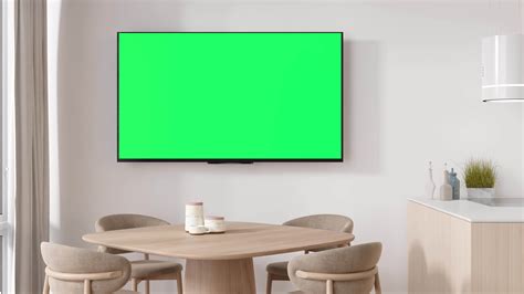 LED TV with blank green screen, hanging on the wall at home. TV video ...