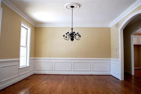 Sunny yellow dining room with arched doorway, elegant wood wainscoting ...