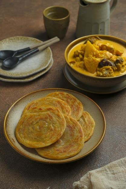 A plate of roti canai roti cane roti maryam or paratha parotta in brown ...