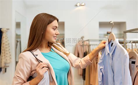 购物,时尚,销售人们的快乐的轻女人选择衬衫商场服装店快乐的女人服装店挑选衣服高清图片下载-正版图片300052216-摄图网