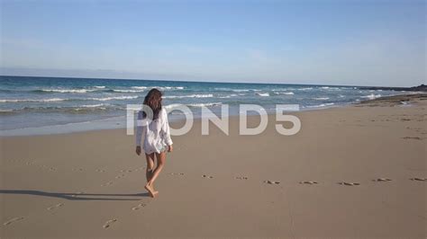 Woman Walking Alone On Beach
