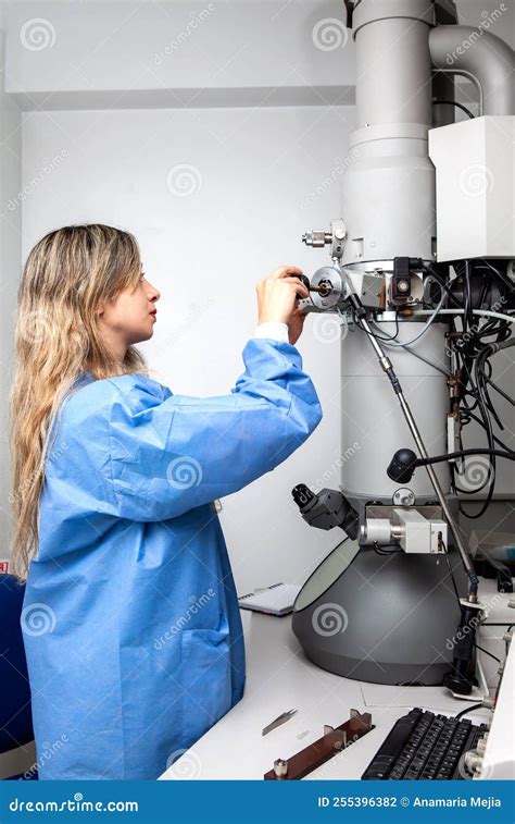 Young Female Scientist Loading a Specimen Using a Sample Holder into a ...
