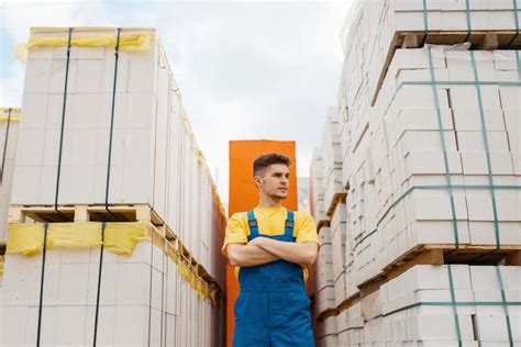 Male builder between big pallets of building materials in hardware ...