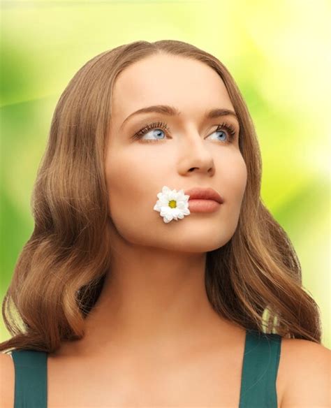 Picture of beautiful woman with camomile in mouth | Premium Photo
