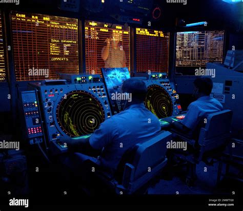 Crew members use radar screens to monitor air operations from the combat information center to ...