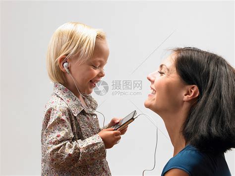年轻美丽的母亲和女儿一起听音乐的高清图片下载-正版图片504722147-摄图网