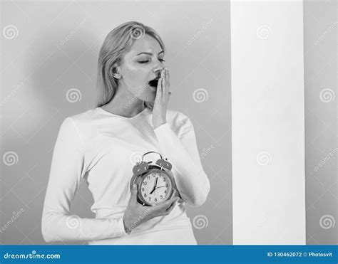 Oversleeping Side Effects is Too Much Sleep Harmful. Girl Yawning Face Just Woke Up Holds Alarm ...