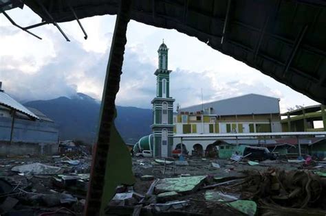 People walk through a completely destroyed residential area after an ...
