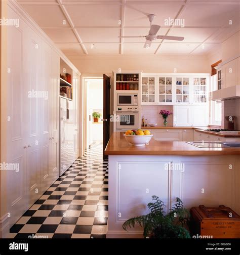 Black+white checkerboard vinyl flooring in large modern white kitchen ...
