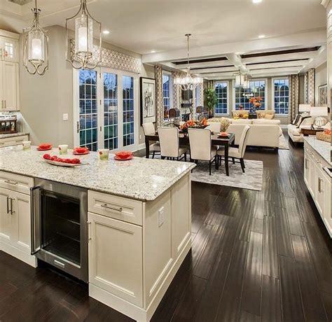 living room kitchen open concept with light wood floor dark cabinets