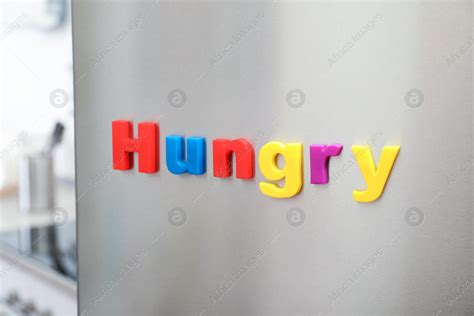 Word HUNGRY of magnetic letters on refrigerator door indoors: Stock ...