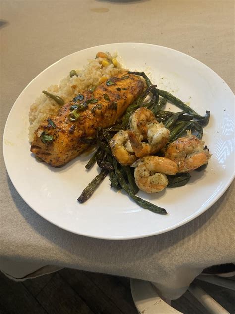 [homemade] Jerk style Salmon on a bed of Spanish rice with Garlic shrimp on sautéed asparagus ...
