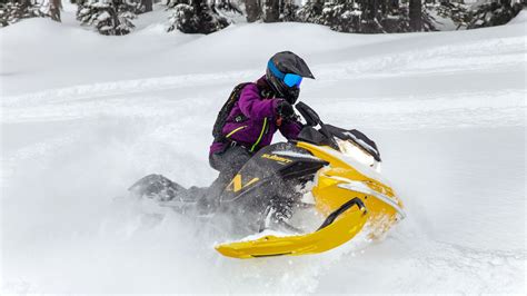 Rider riding up a snowy mountain on the 2027 Ski-Doo Summit