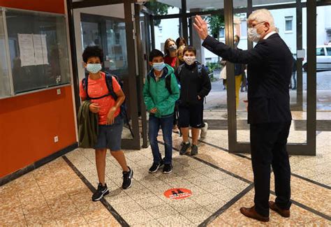 Students wearing protective face masks respect social distancing as ...