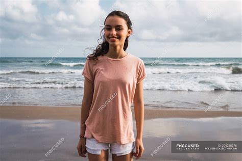 Portrait of smiling teen girl standing on beach — seashore, childhood ...