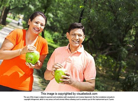 Happy Indian Married Couple Drinking Coconut Water Refreshment Morning Park