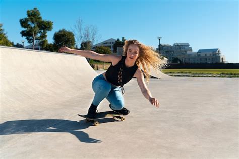 Ragazza del colpo pieno che fa trucco sullo skateboard | Foto Gratis